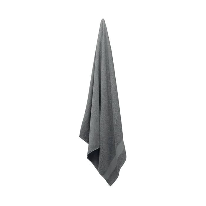 A grey towel hanging, featuring a textured design and a simple, elegant shape. It has a logo on one corner.