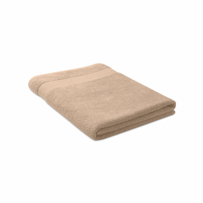 A folded towel in a soft beige colour, featuring a smooth strip along one edge. It has a simple design and a plush texture.