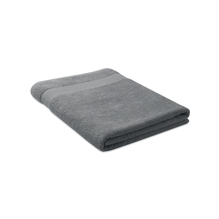 A grey bath towel, neatly folded with a contrasting stripe across one edge, displaying a soft, textured surface.