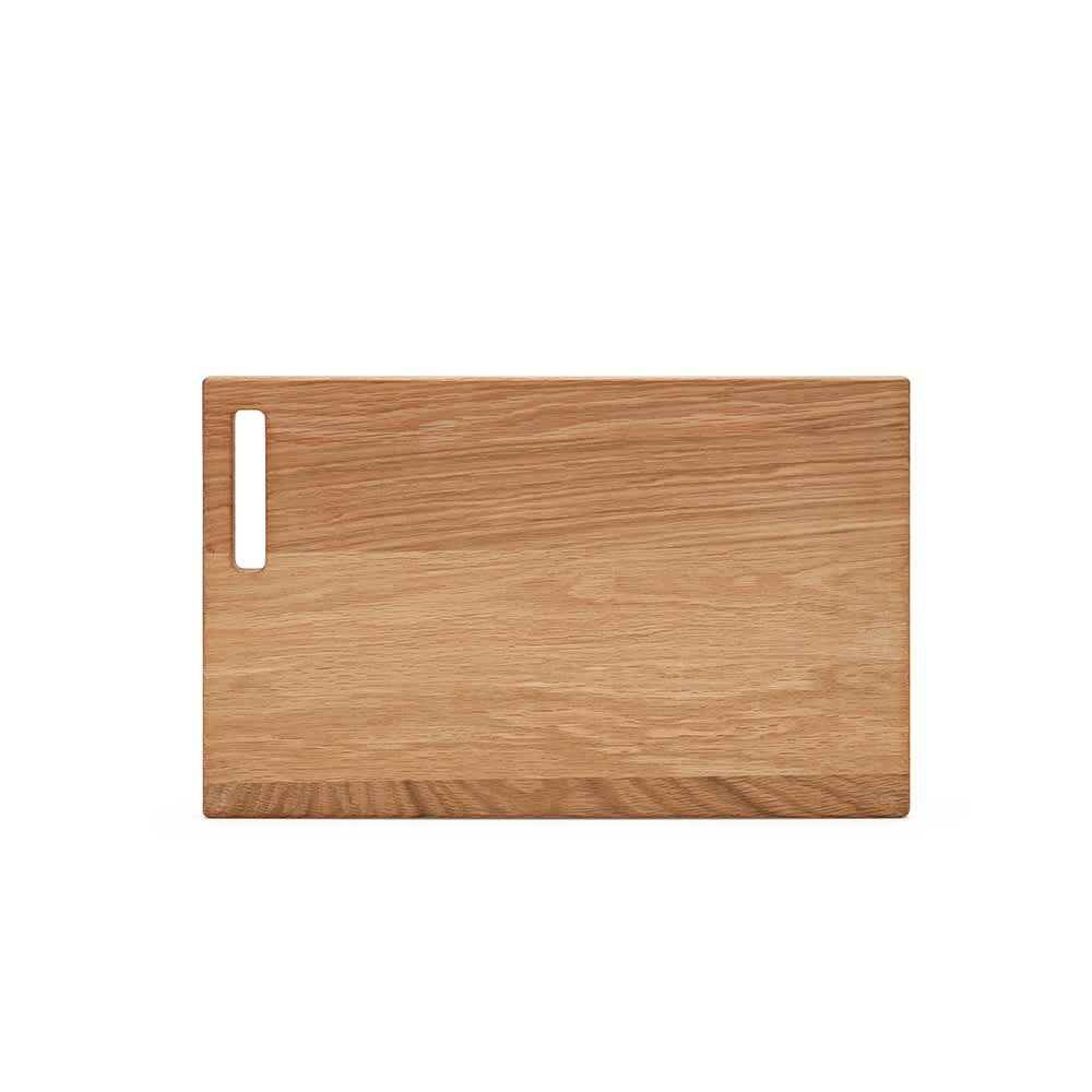 A wooden cutting board in light oak with a built-in handle on one side. It has a smooth surface and natural finish.