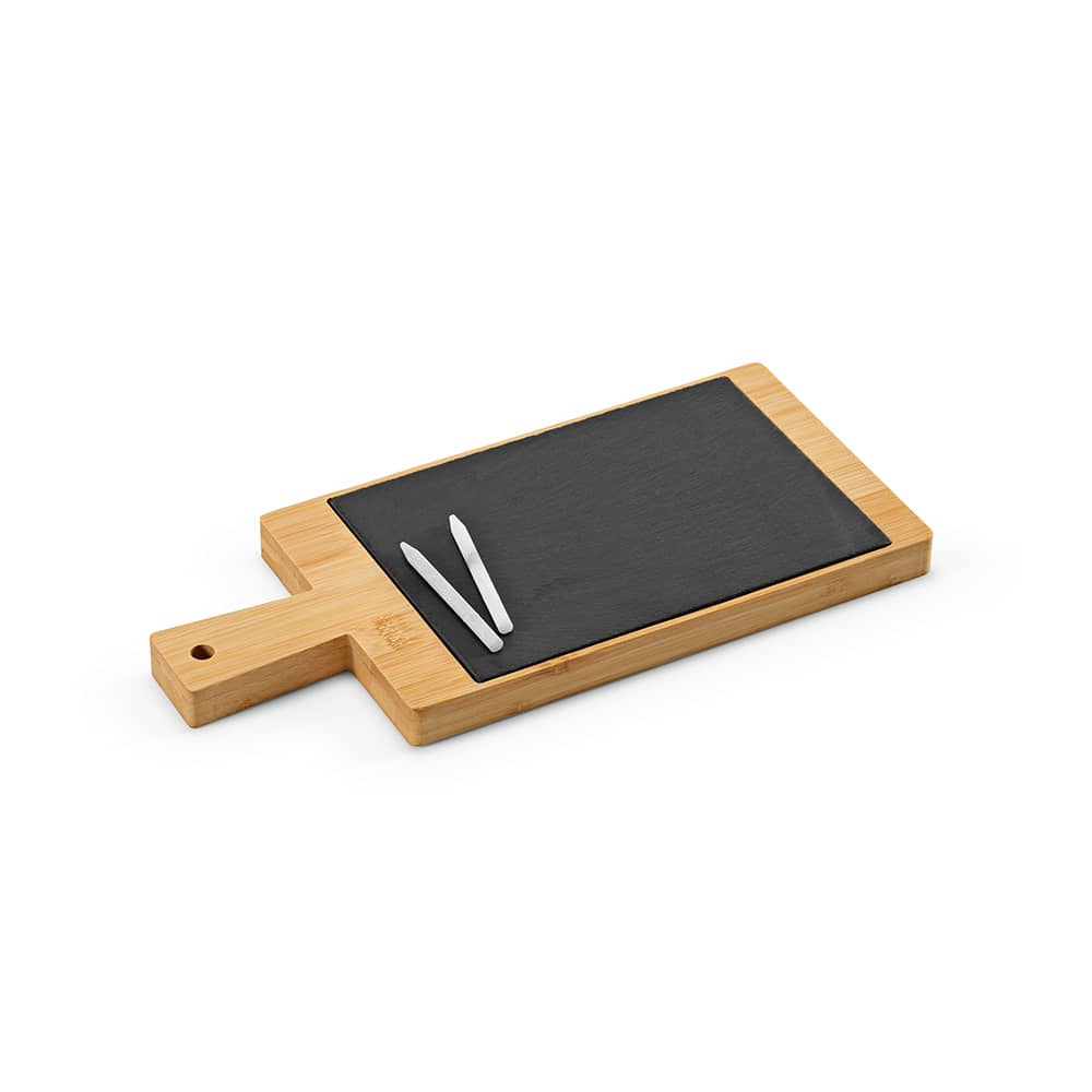 A bamboo serving board with a black slate surface and two white chalk pieces. The board features a handle.