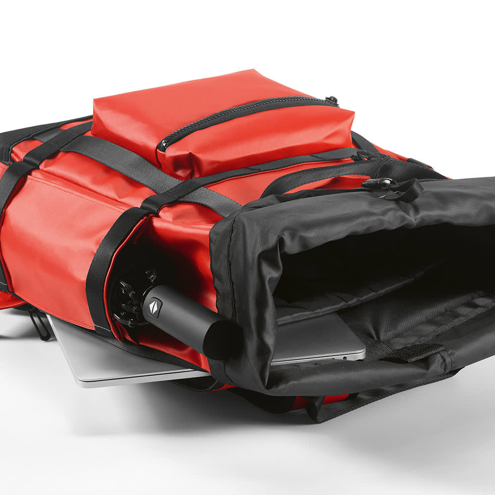 A red and black backpack with a magnetic closure, featuring compartments for a 17" laptop and other items.