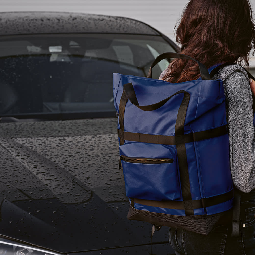 A blue backpack with black accents featuring a magnetic closing, designed to fit a 17" laptop.
