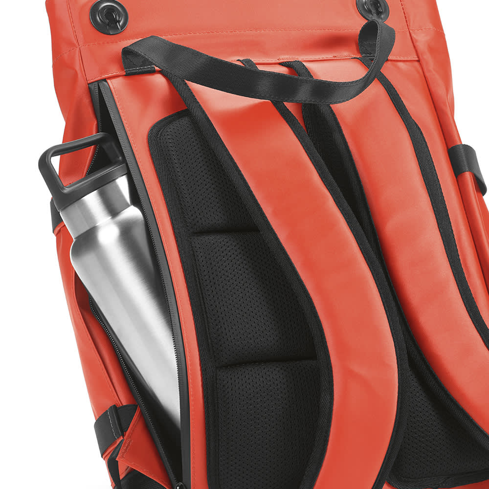 A red Wellington backpack featuring a magnetic closing, padded straps, and a silver drink bottle in a side pocket.