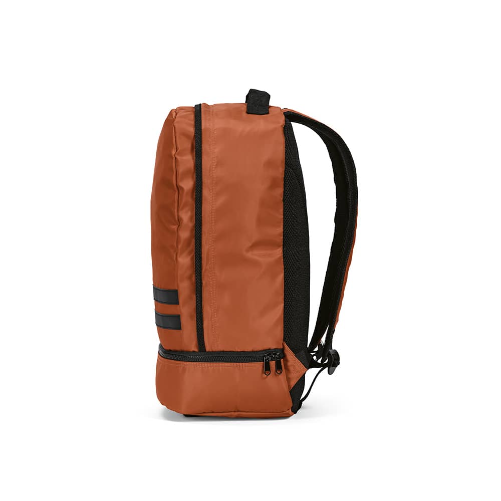 A rust-coloured backpack featuring reflective front strips and a zippered compartment. One side displays a mesh panel.