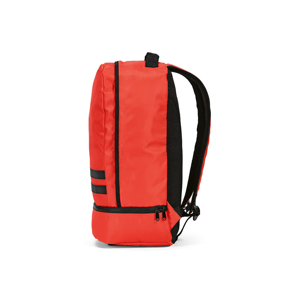 A red backpack with black reflective strips, featuring padded shoulder straps and a zippered compartment.
