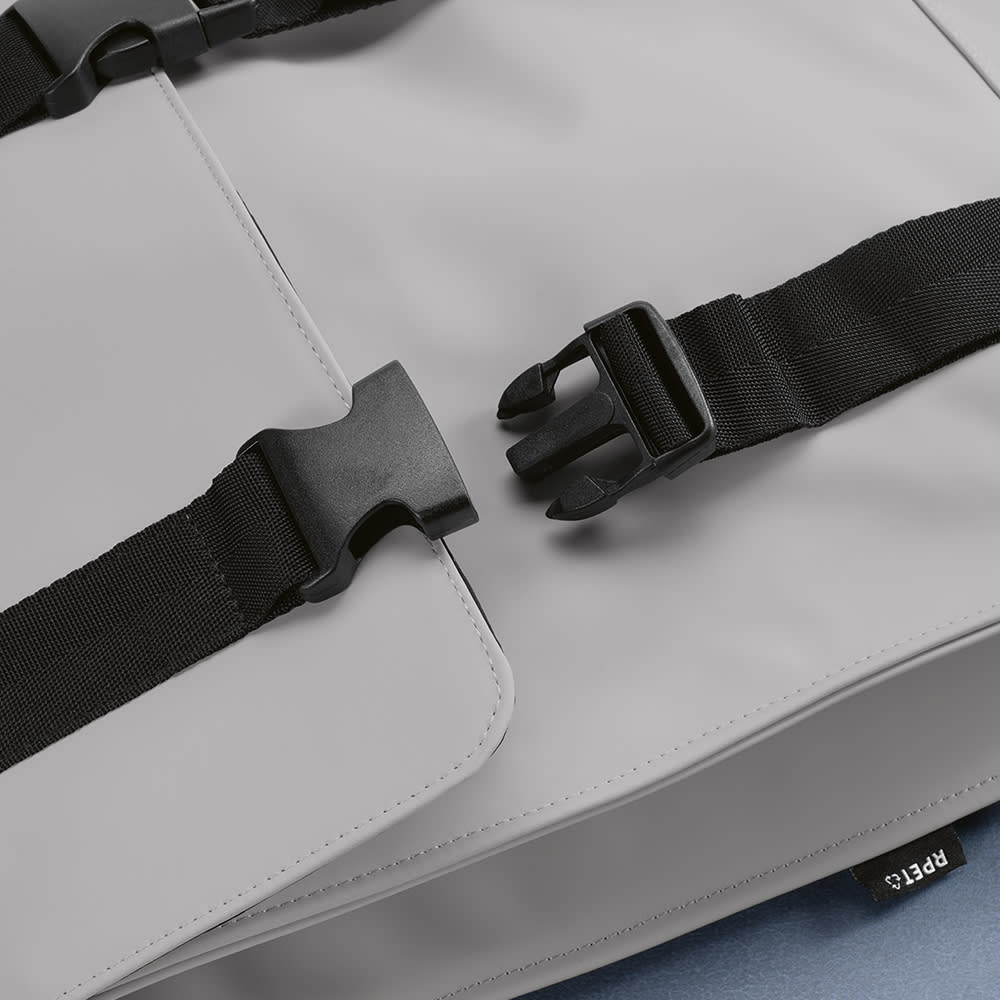 A grey backpack featuring adjustable straps and a buckle closure, designed for a 17" laptop. Includes branding.