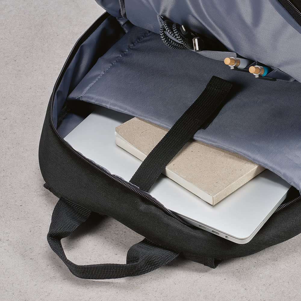 A black backpack with a grey interior, featuring a laptop compartment and a notebook inside.