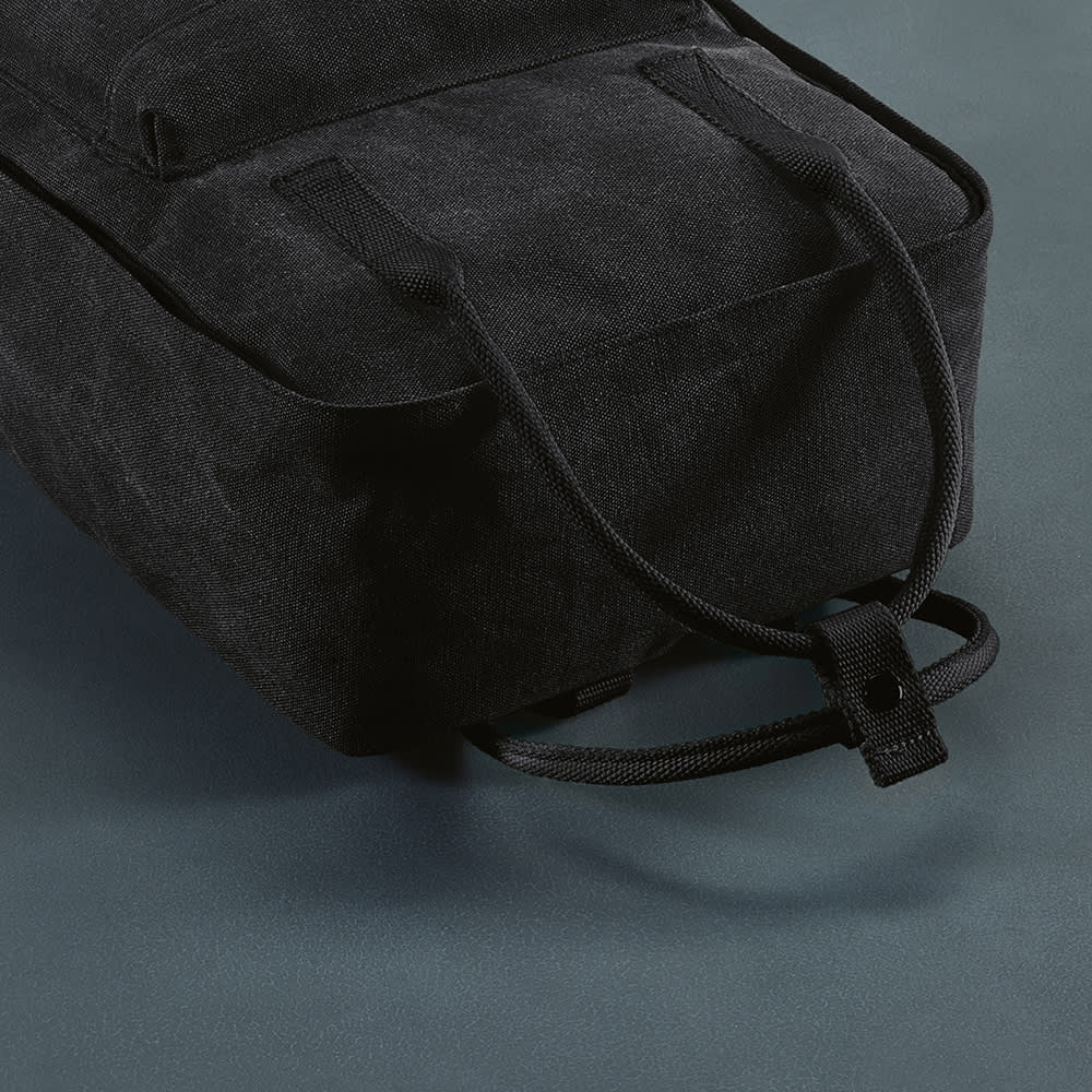 A black backpack with rPET handles and a textured surface, featuring a minimalist design and a logo.