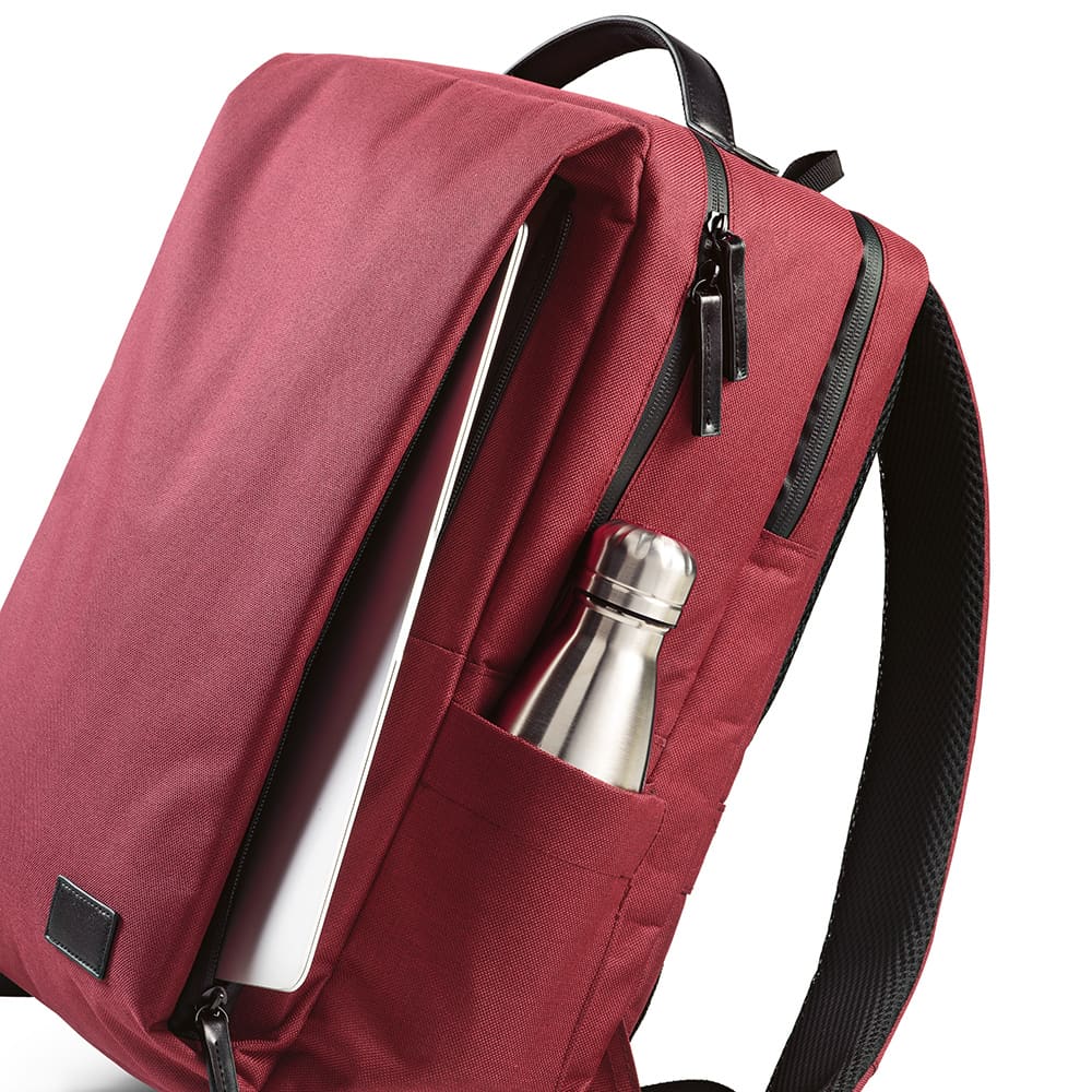 A maroon backpack with waterproof zippers, featuring a side pocket for a drink bottle and space for a 17" laptop.