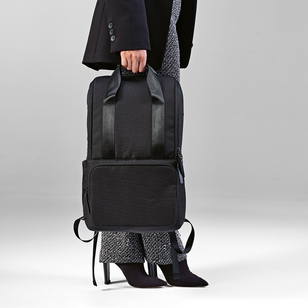 A black backpack with dual handles and a front pocket, designed to fit a 15.6" laptop. It has a logo.