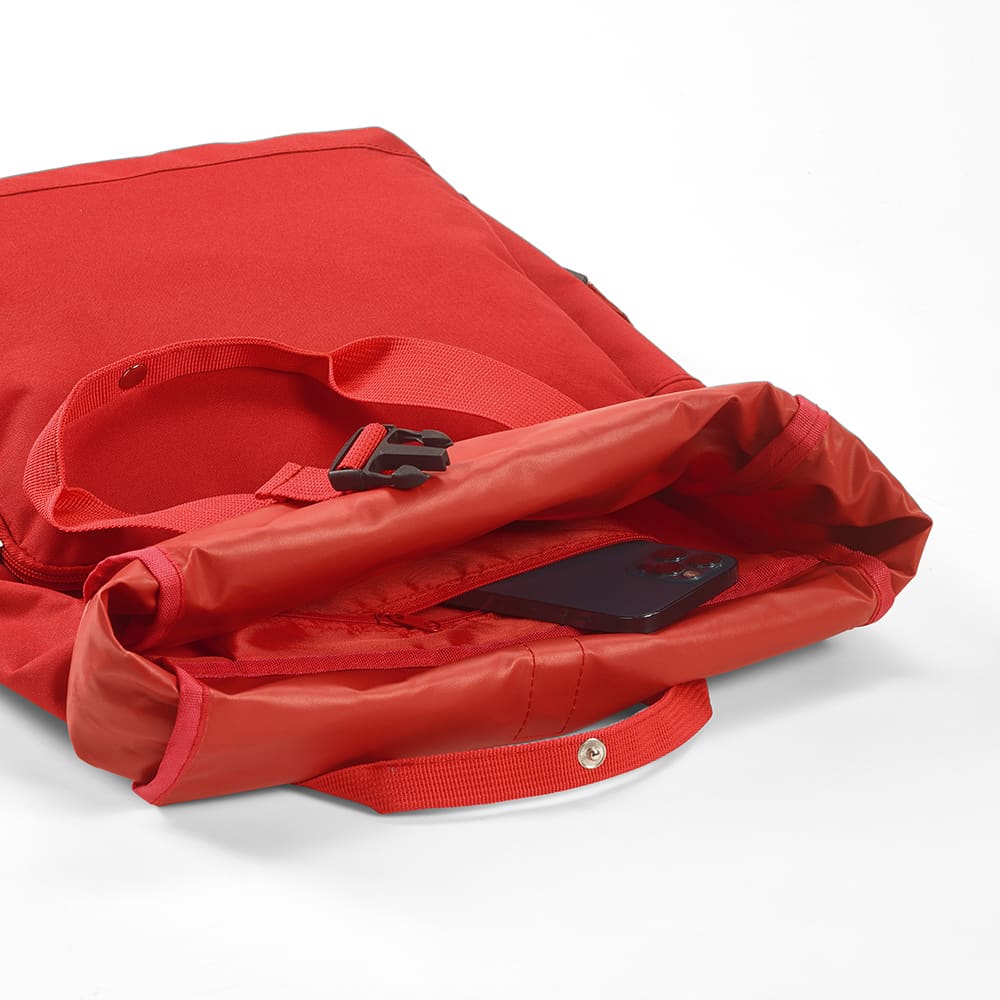 A red backpack with a roll top and buckle closure, featuring a phone inside and a logo on the exterior.