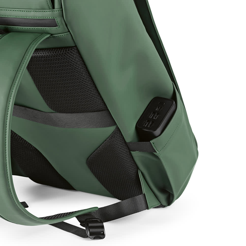 A green backpack with a textured side panel and a partially visible device pocket. The bag has a logo.