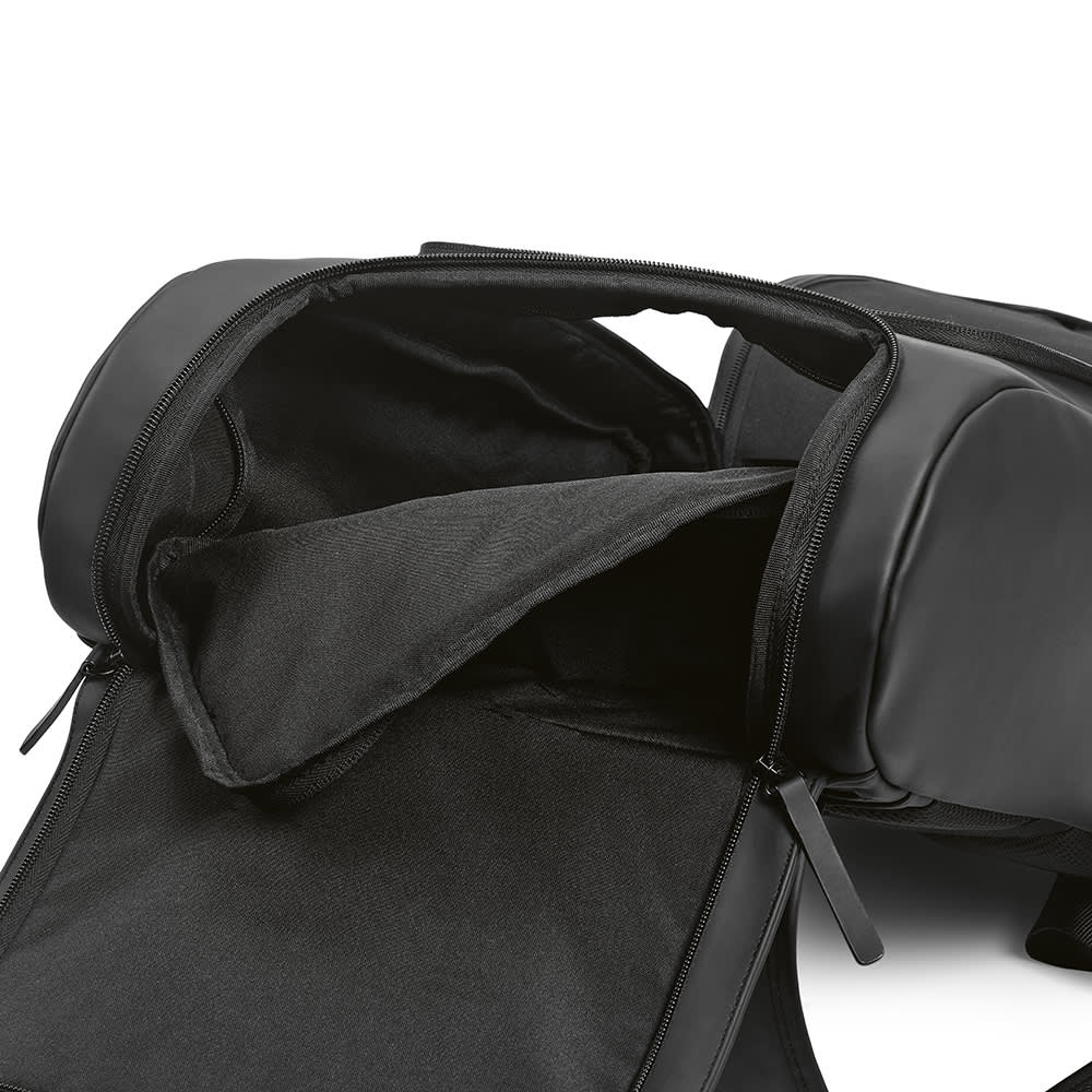 A black backpack with an open main compartment, revealing a padded pocket for a laptop and additional storage space.