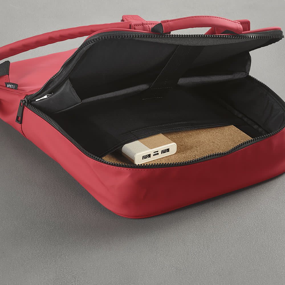 A red Amsterdam backpack with an open zipper, revealing a sleek interior and a cork pad inside. It has a logo.