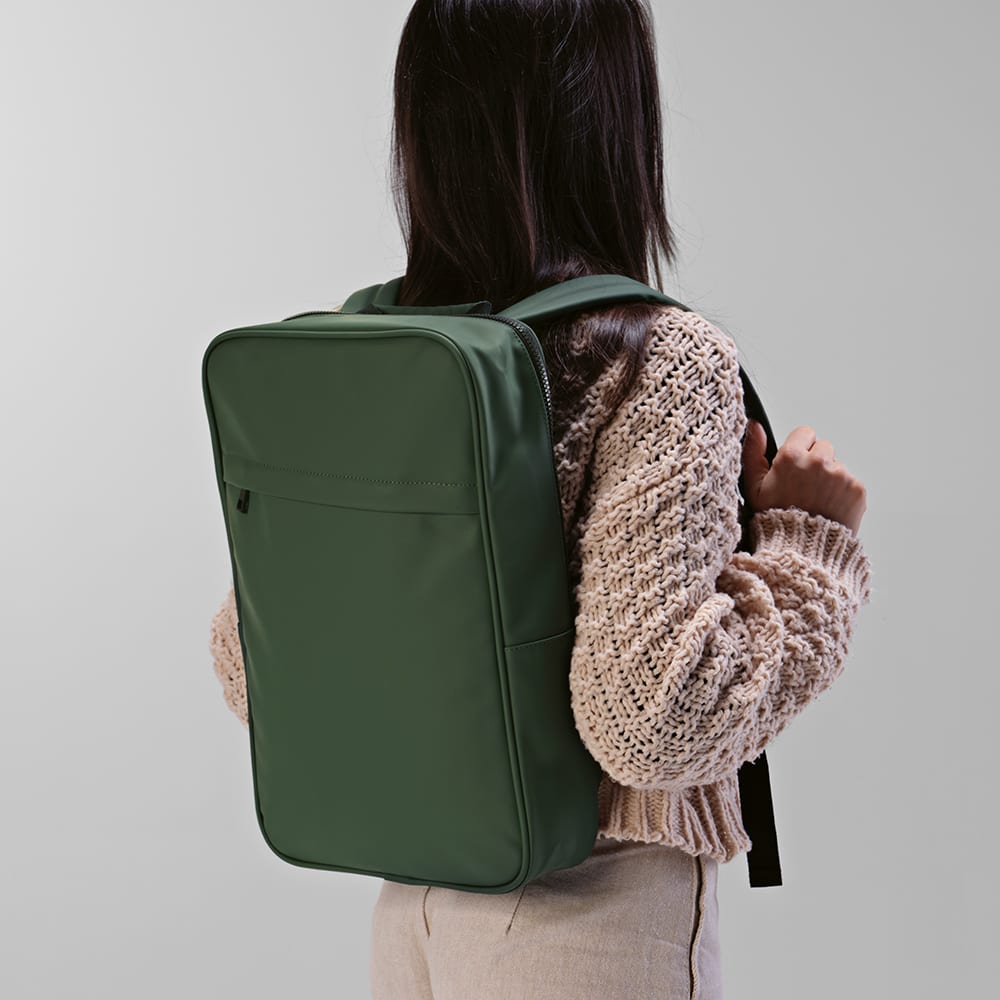 A green backpack with padded straps, featuring a front pocket and designed to fit a 17" laptop.