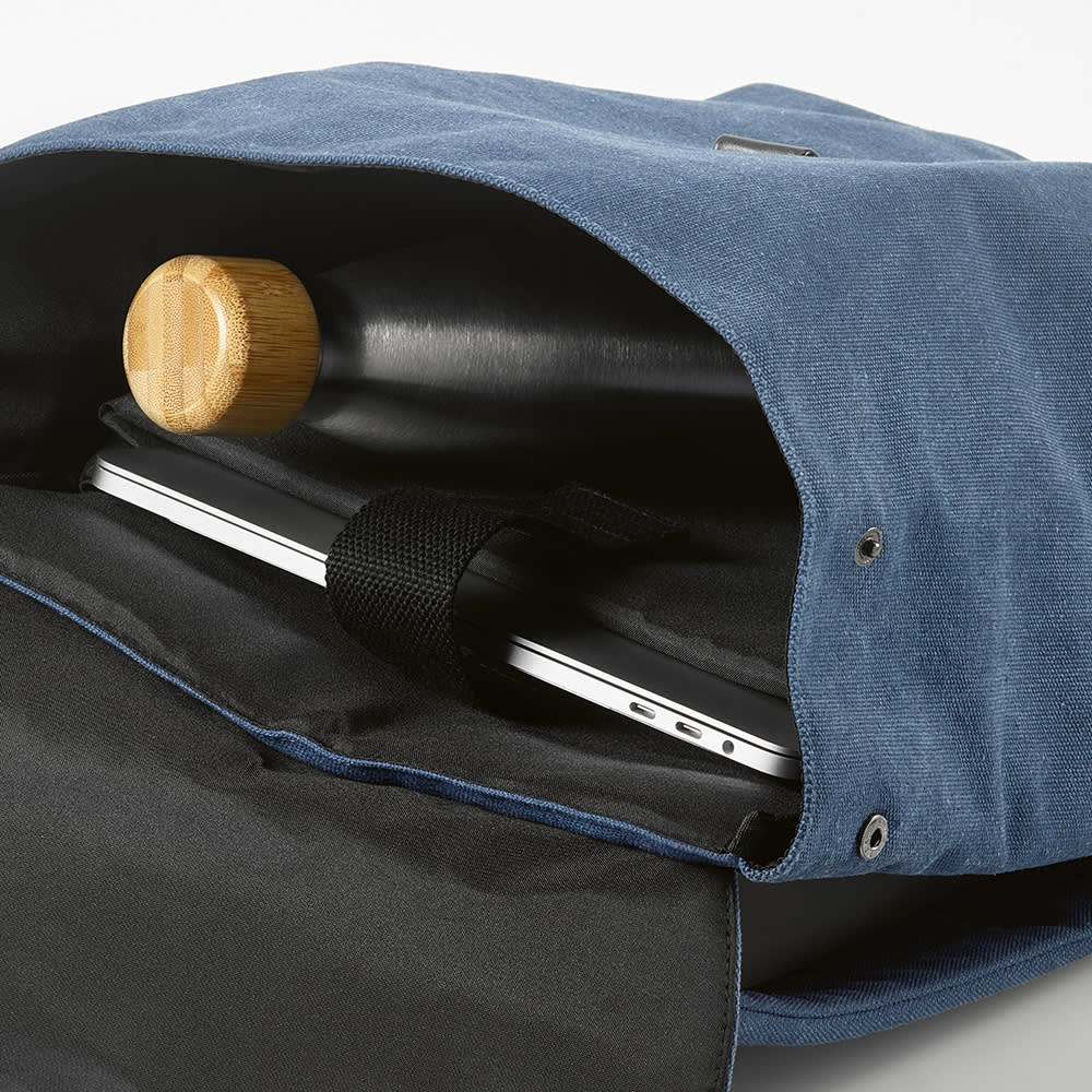 A blue backpack interior displaying a padded section for a 17" laptop and a drink bottle. It features a hook closure and a logo.