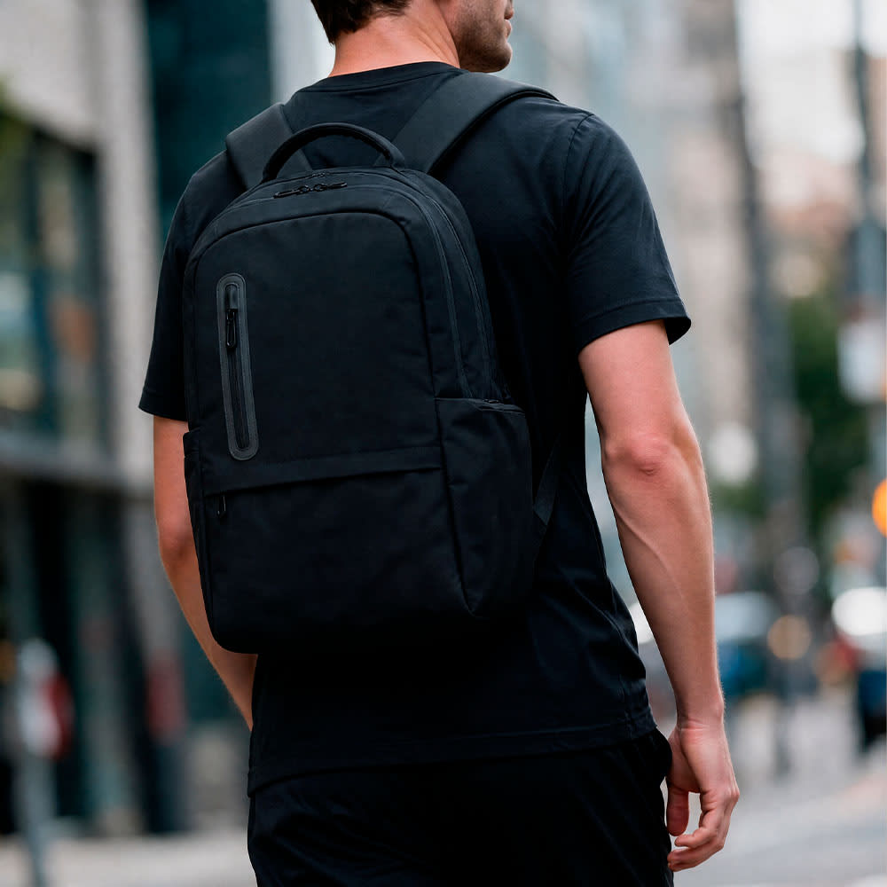 A black backpack with a sleek design, featuring a front zip pocket and padded shoulder straps.