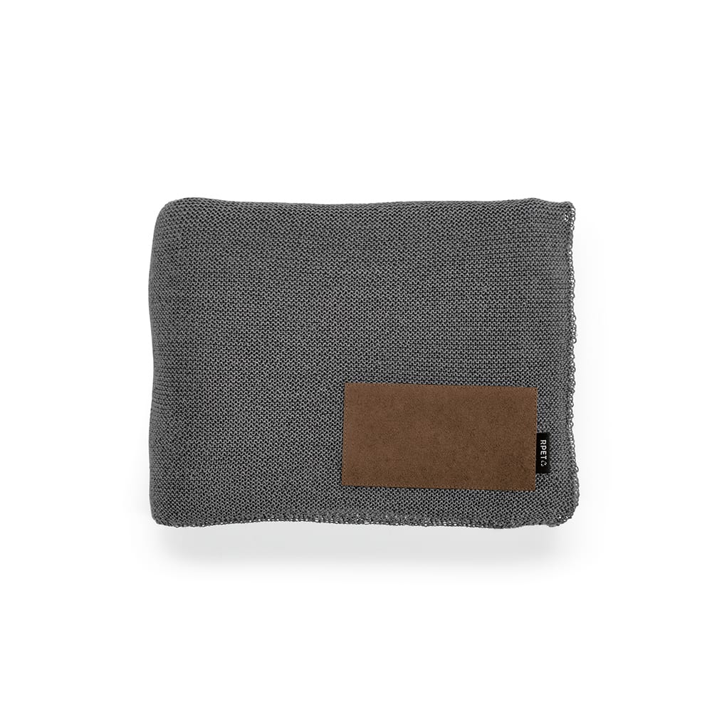 A grey blanket made from rPET and wool blend, featuring a customisable patch and a small branding label.