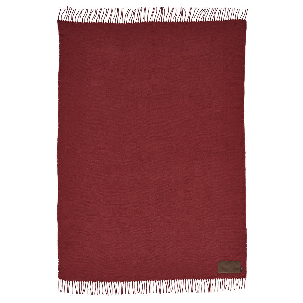 A maroon blanket with fringe edges, featuring a customisable patch and a branding logo.