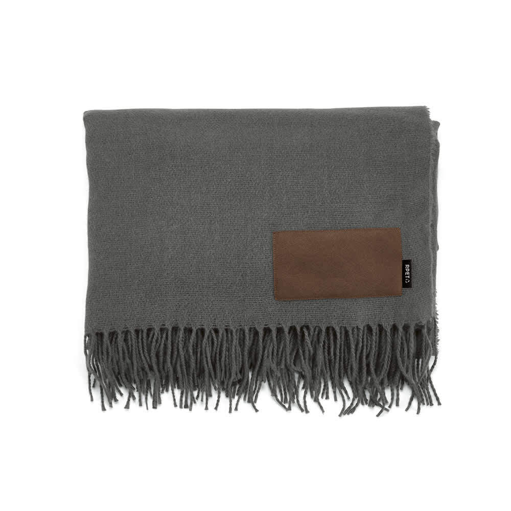 A grey blanket made from rPET material, featuring a customisable brown patch and fringe detailing.