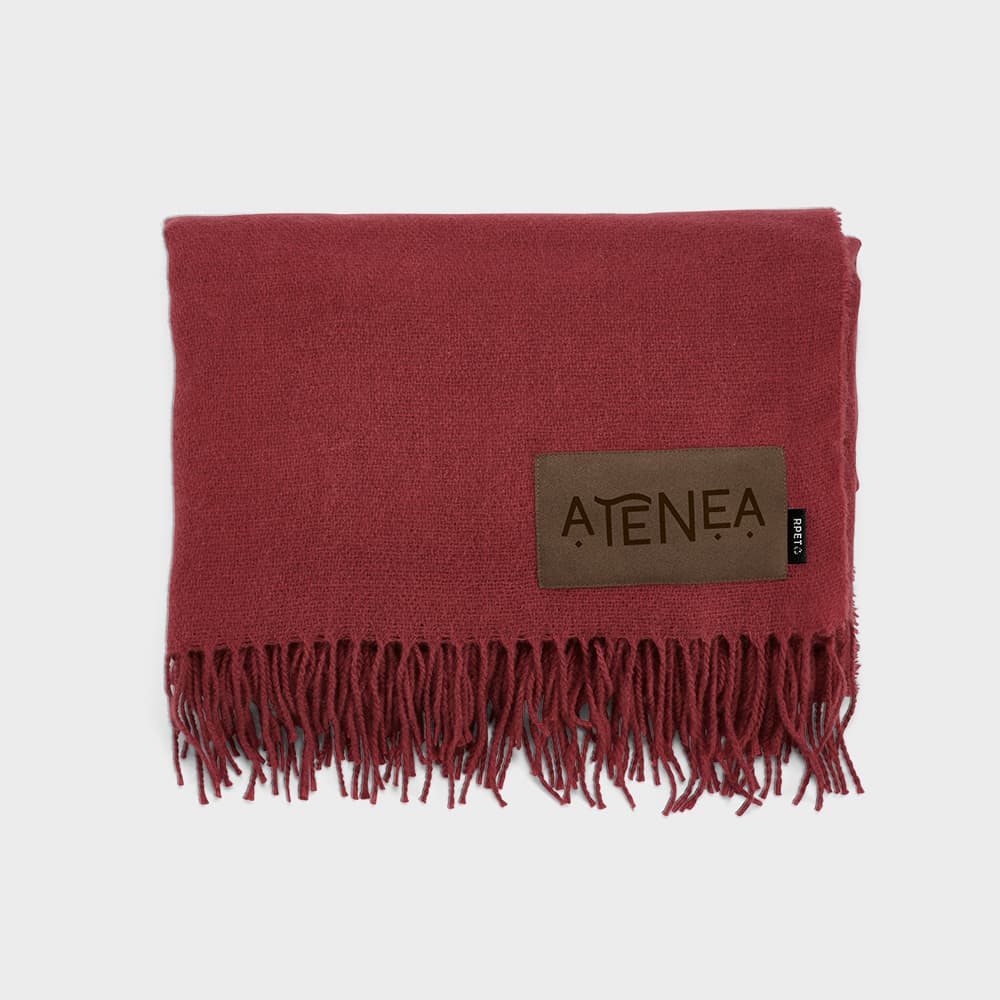 A maroon Lichtenstein blanket made from rPET, featuring a fringed edge and a customisable patch.