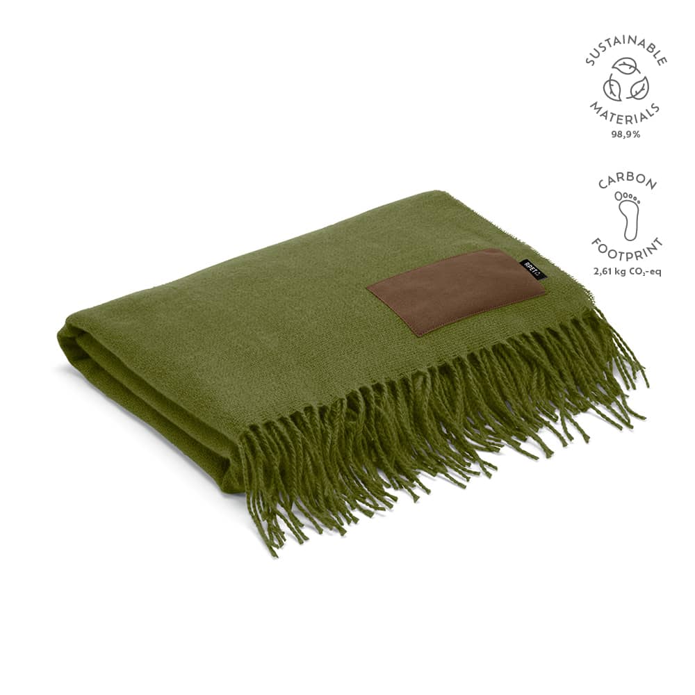 An olive green blanket with a brown patch and fringed edges, made from sustainable materials.