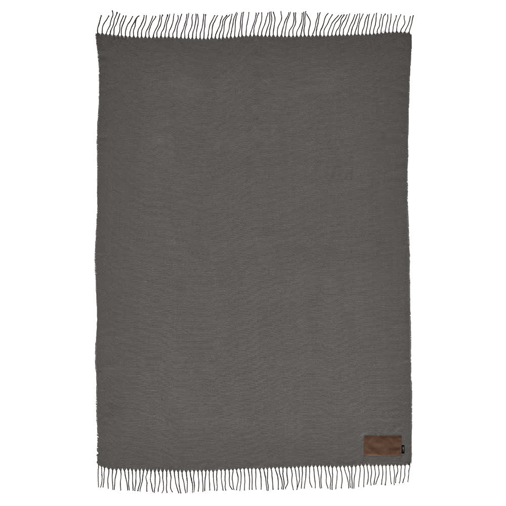 A grey Lichtenstein blanket made of rPET with tasselled edges and a small branding label.