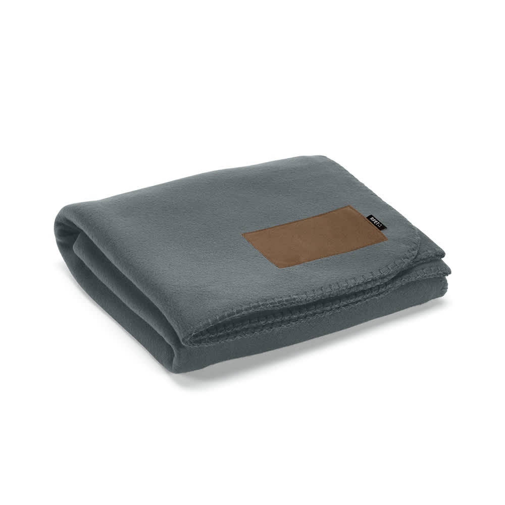 A folded grey blanket made from rPET fabric, featuring a customisable brown patch and a subtle brand logo.