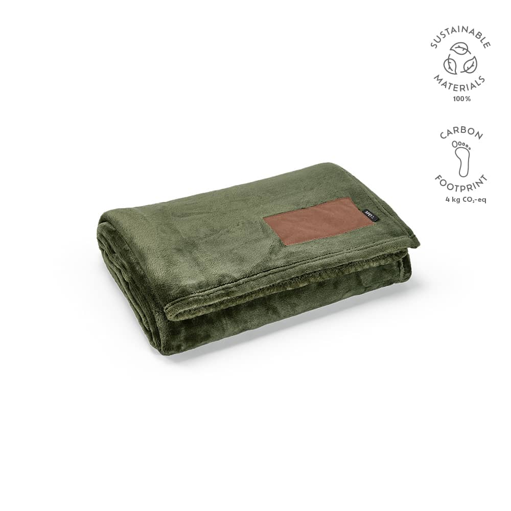 A green blanket made from sustainable materials, featuring a customisable brown patch. It has a soft, plush texture.