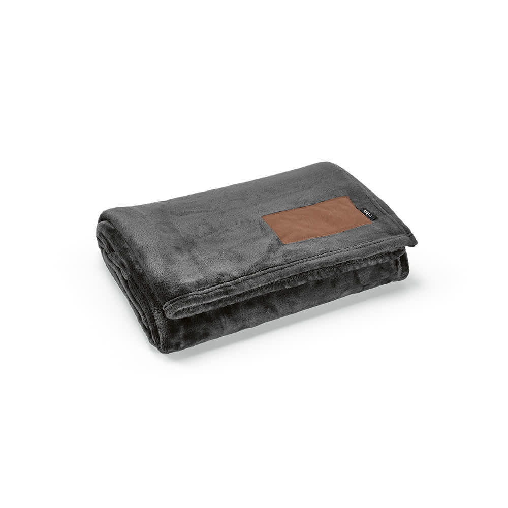 A soft, grey blanket with a brown customisable patch, neatly folded. It features a logo on the edge.