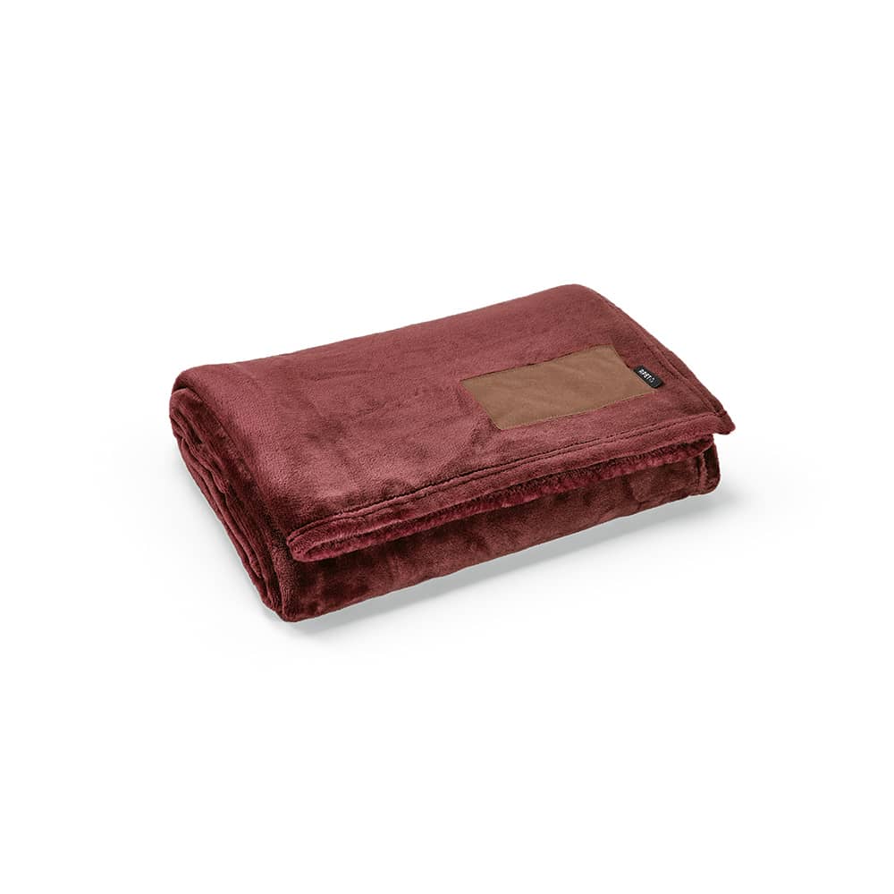 A maroon blanket made from rPET with a customisable patch. It features a soft, plush texture.