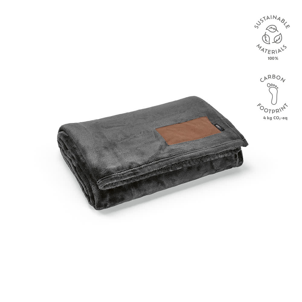 A folded grey blanket with a brown patch, made from sustainable materials. It features a logo.