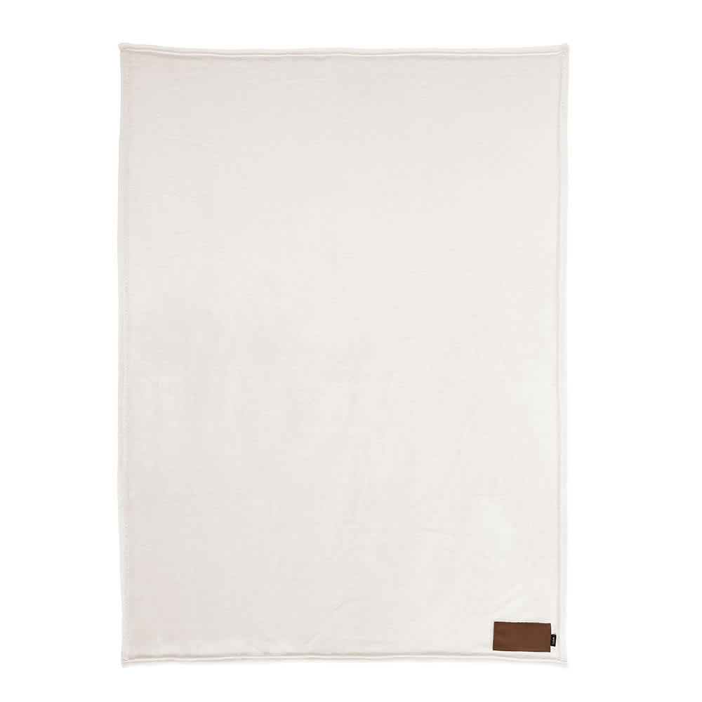 A cream-coloured blanket made from rPET with a customisable patch and a brown logo tag.