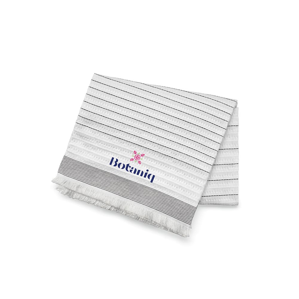 A striped, white cotton blanket with navy lines and fringed edges, featuring a logo.