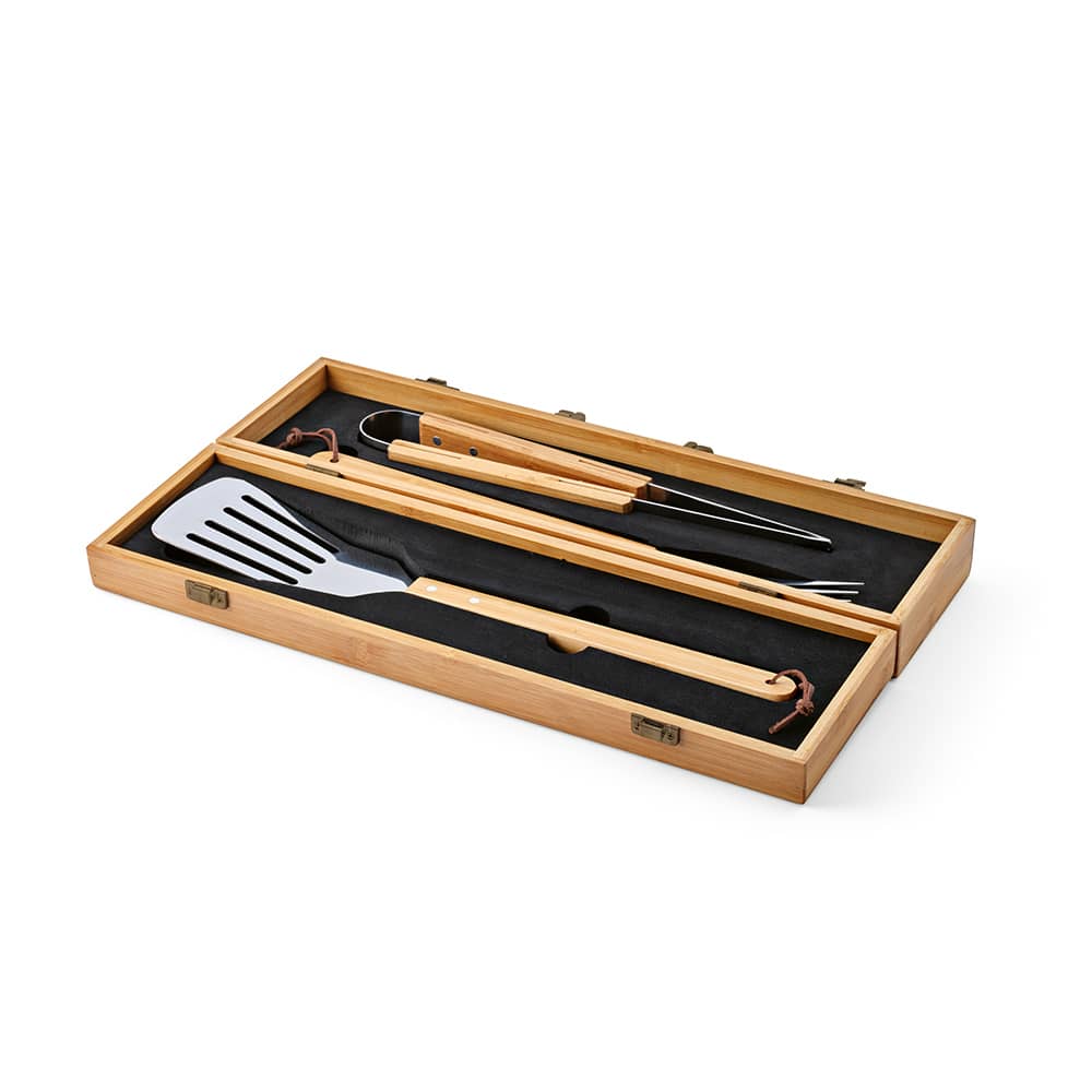 A bamboo barbecue set in a case, featuring a spatula, tongs, and fork, all with wooden handles.