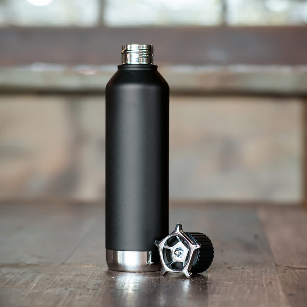 A drink bottle in matte black with a wheel-shaped lid, featuring a double wall and leakproof design.