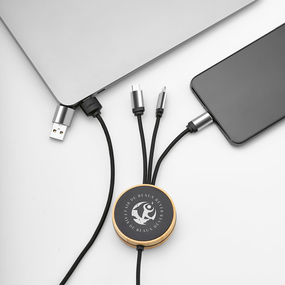 A bamboo and rPET charging cable in black, featuring a backlit logo, connected to a smartphone and laptop.
