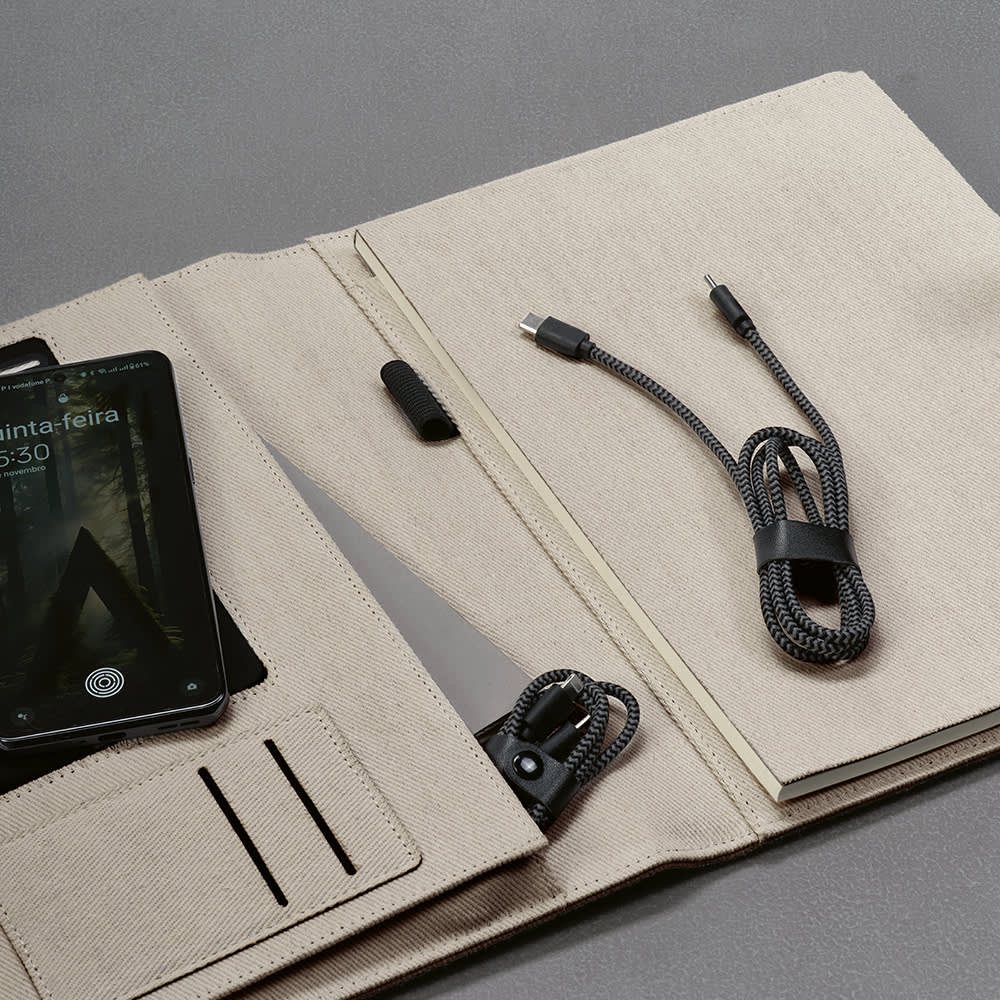 A beige folder with a USB-C to Lightning charging cable and a smartphone resting inside. It features a logo.