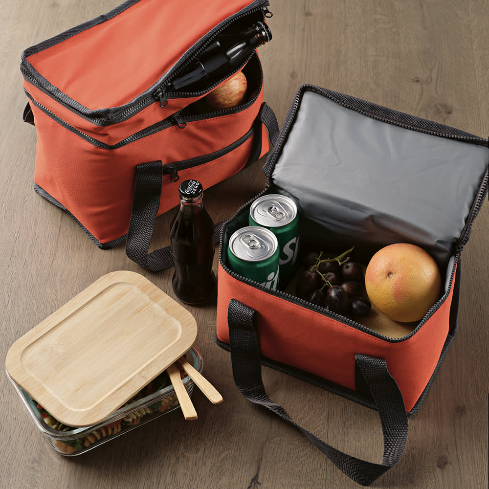 A red cooler bag with zippers, featuring a grey interior. It contains drinks and fruits, alongside a bamboo container.