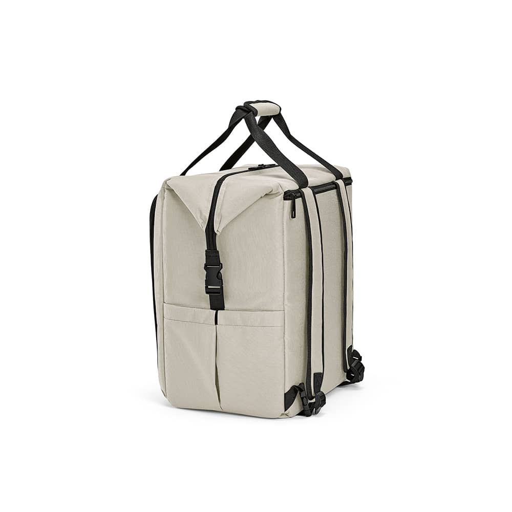 A beige cooler with a front pocket and two side pockets, featuring adjustable shoulder straps and a logo.