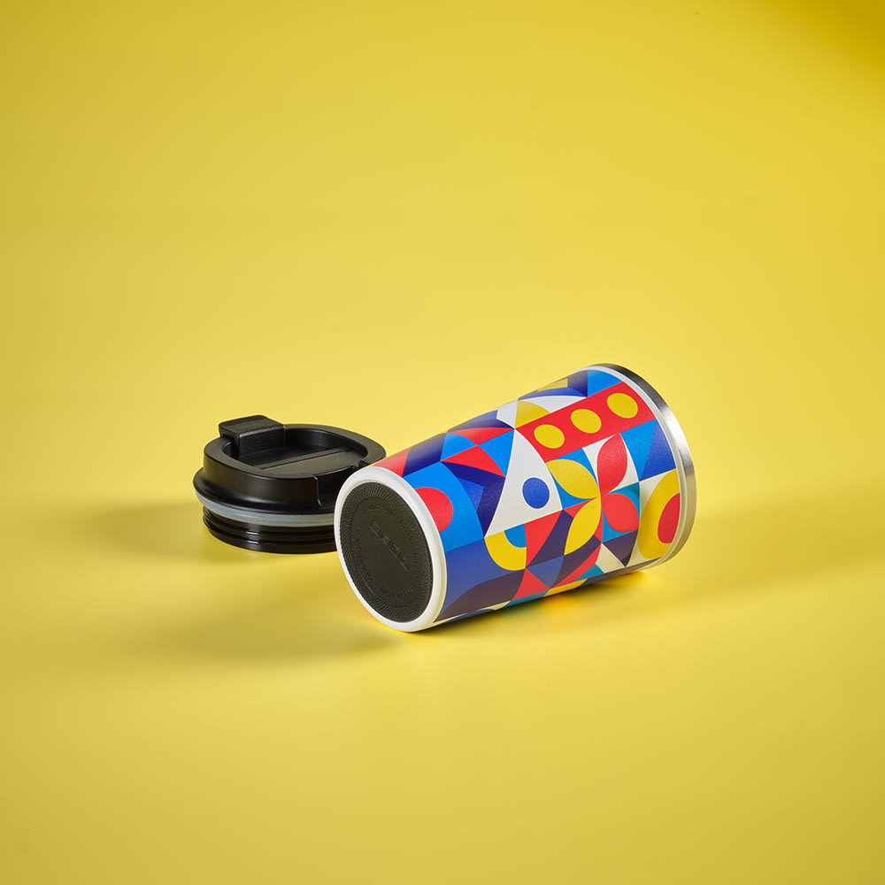 A drink bottle featuring a colourful geometric design with a black lid, showcasing blue, red, yellow, and green hues.