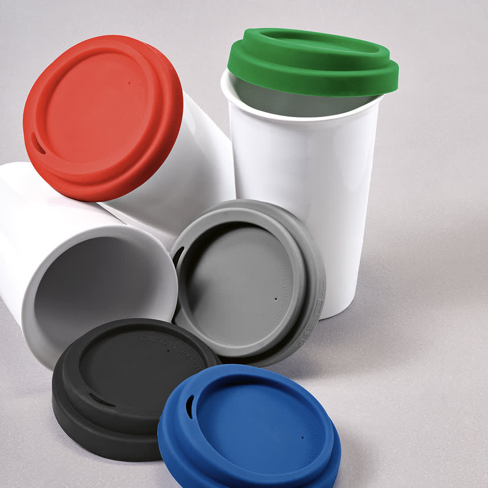 A drink bottle with a white ceramic body and coloured lids in red, green, grey, and blue. It has a logo.