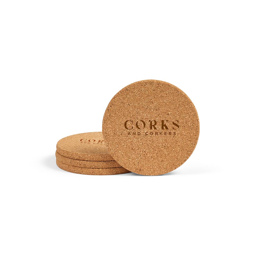 A set of four round cork coasters stacked, featuring a simple logo design on the surface.