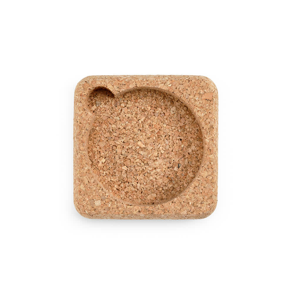 A cork coaster in a square shape with a rounded depression for drinks, showcasing a natural cork colour.