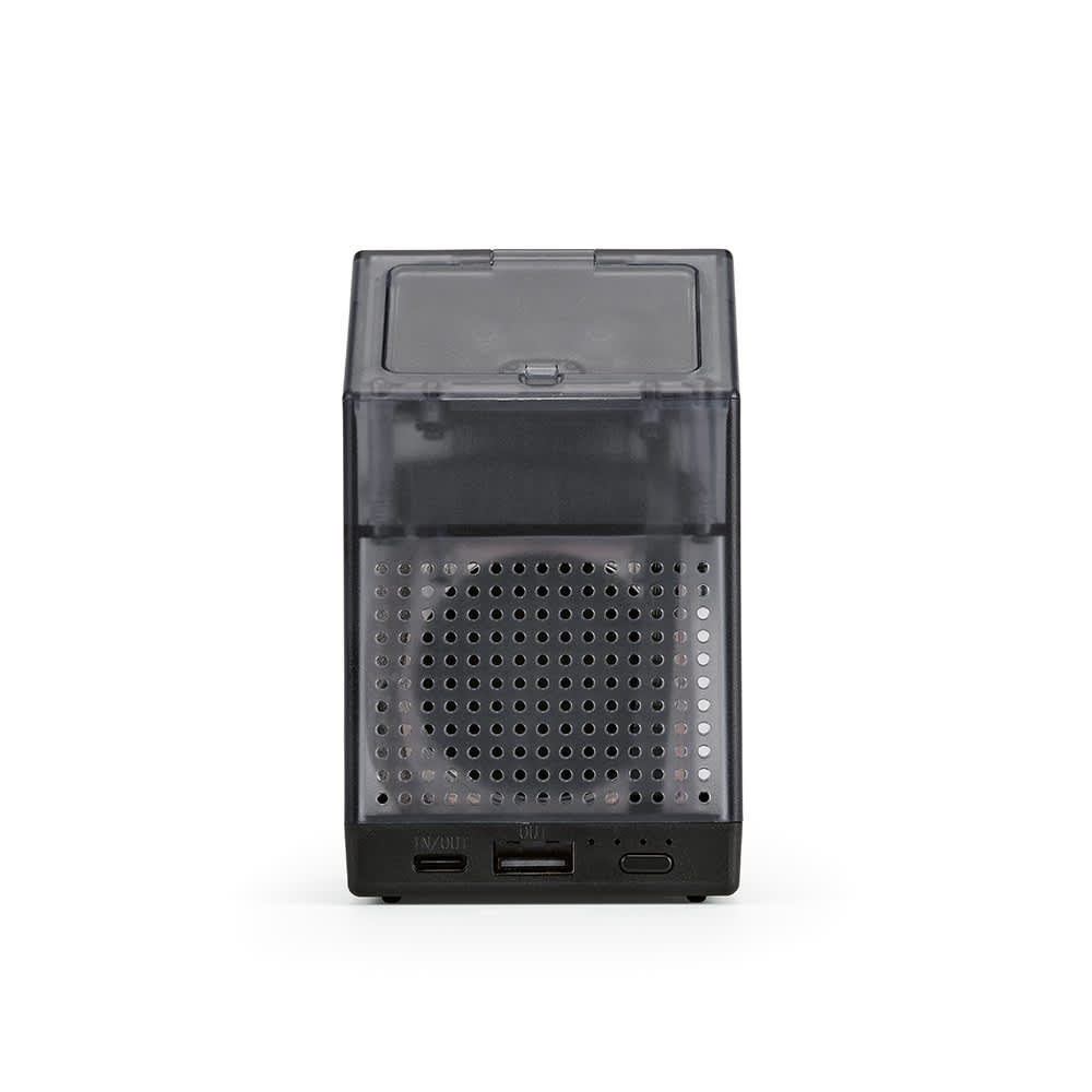 A compact black speaker with a transparent casing, featuring ports on the side for connectivity.