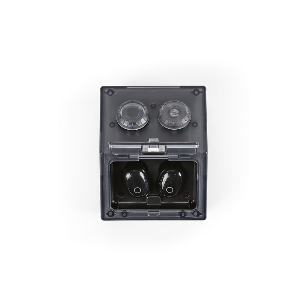 A black set of earbuds and their charging case in a clear, grey protective box, featuring round speaker grills on top.