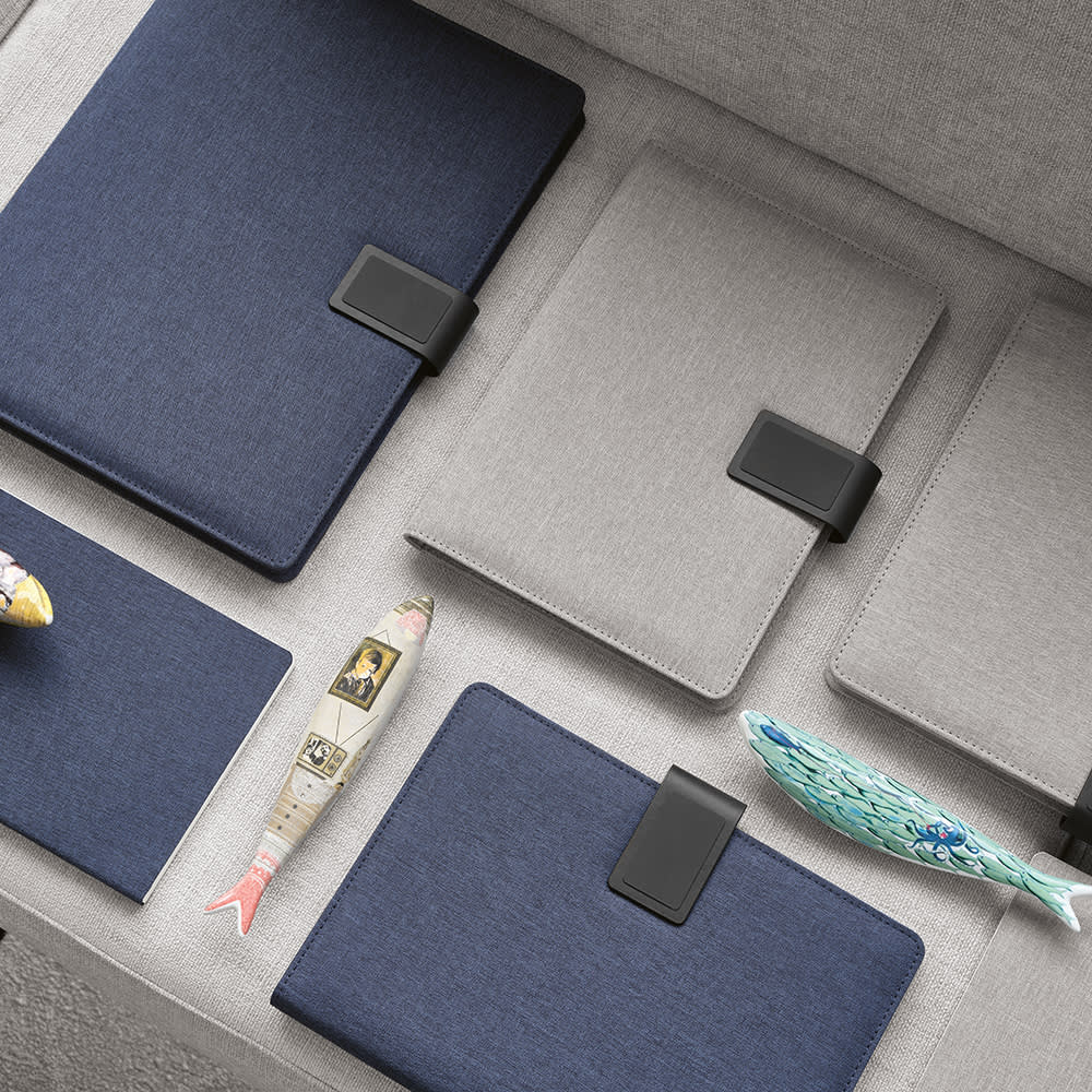 A collection of grey and navy A4 folders with rPU closures, accompanied by decorative fish figurines.