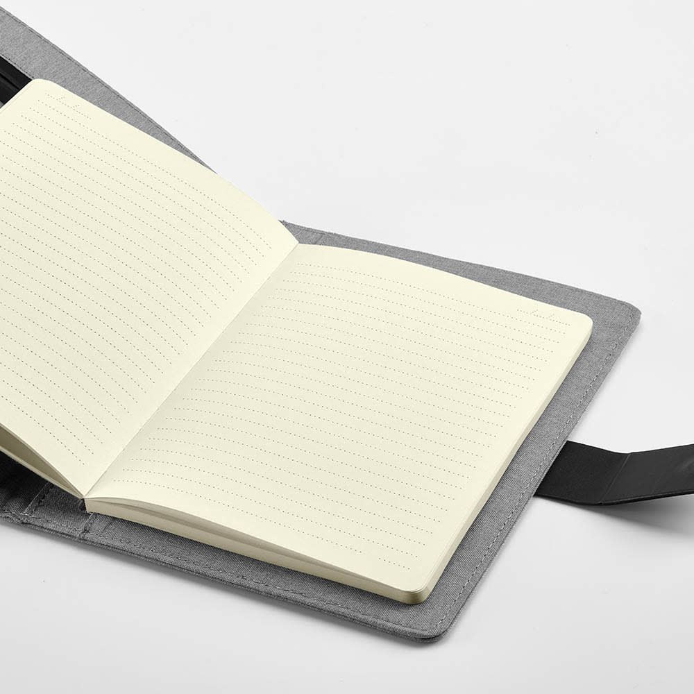 A grey A5 folder featuring a notepad with cream-coloured pages and a black closure strap.