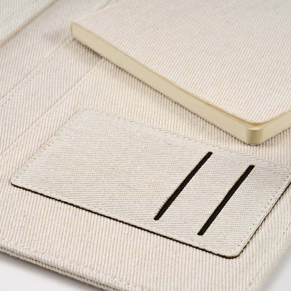 An off-white A4 folder with a notepad and elastic closure, featuring pockets and a branded logo.